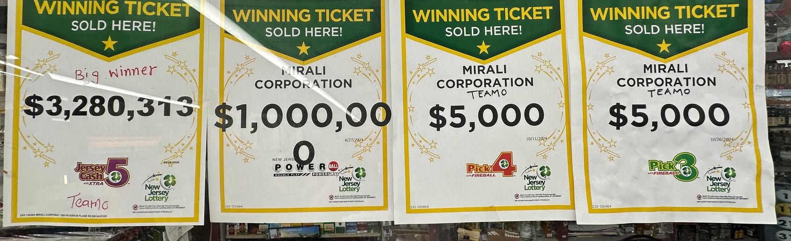 Four New Jersey Lottery 'Winning Ticket Sold Here' certificates displayed at the Te-Amo counter, for prizes of $3,280,313, $1,000,000, $5,000 and $5,000.